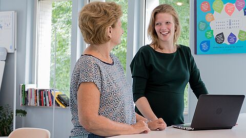 2 personen in gesprek bij laptop