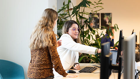 2 collega's die kijken naar beeldscherm